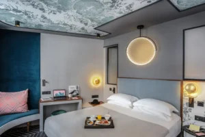 Hotel Louisonin elegantti huone modernilla sisustuksella, mukava sänky ja aamiaistarjotin.