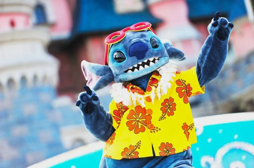 Stitch i sommarkläder framför slottet i Disneyland Paris
